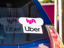 Lyft and Uber stickers on the rear window of a vehicle offering rides in San Francisco Bay Area